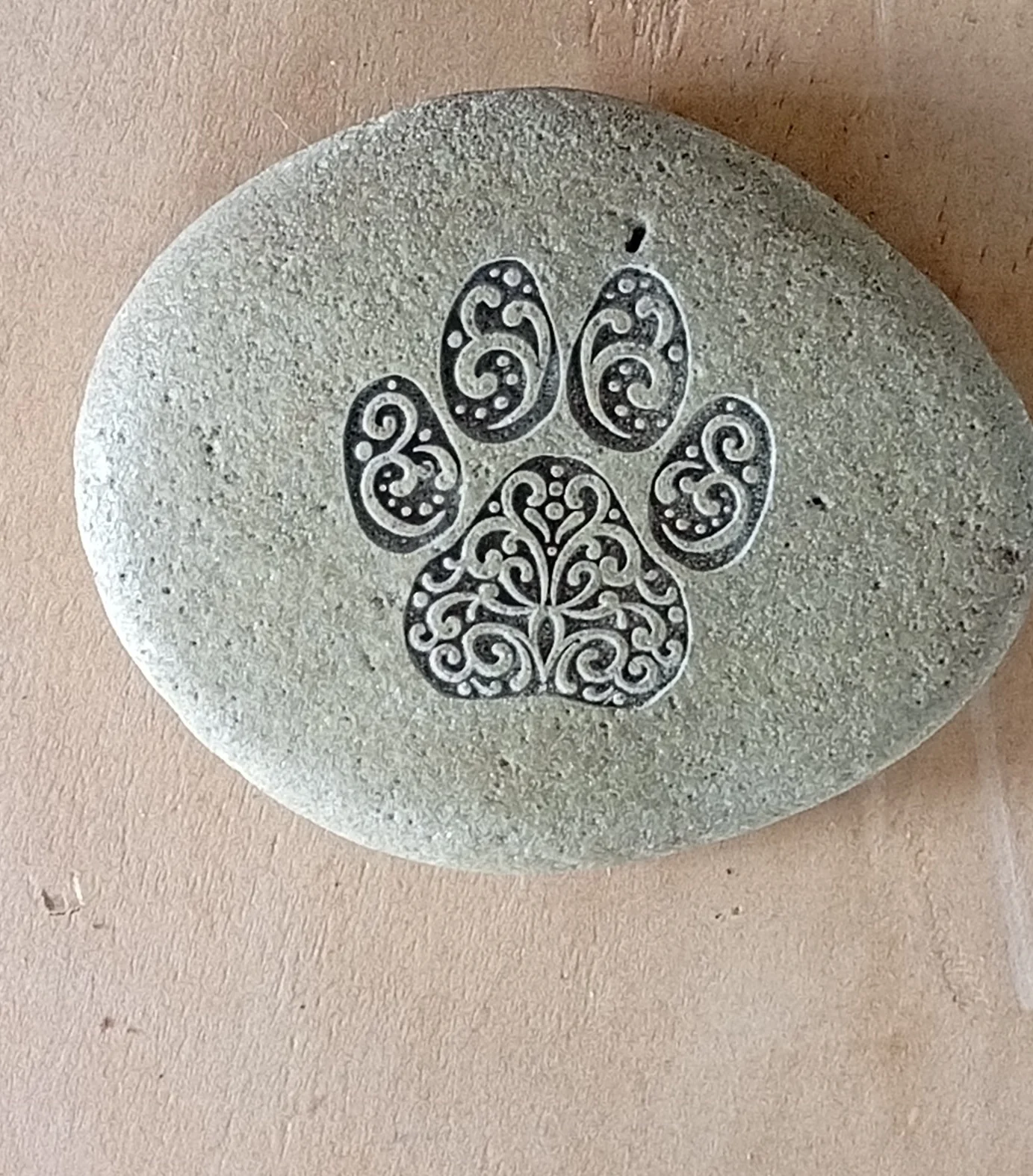Paw print engraved into a river stone